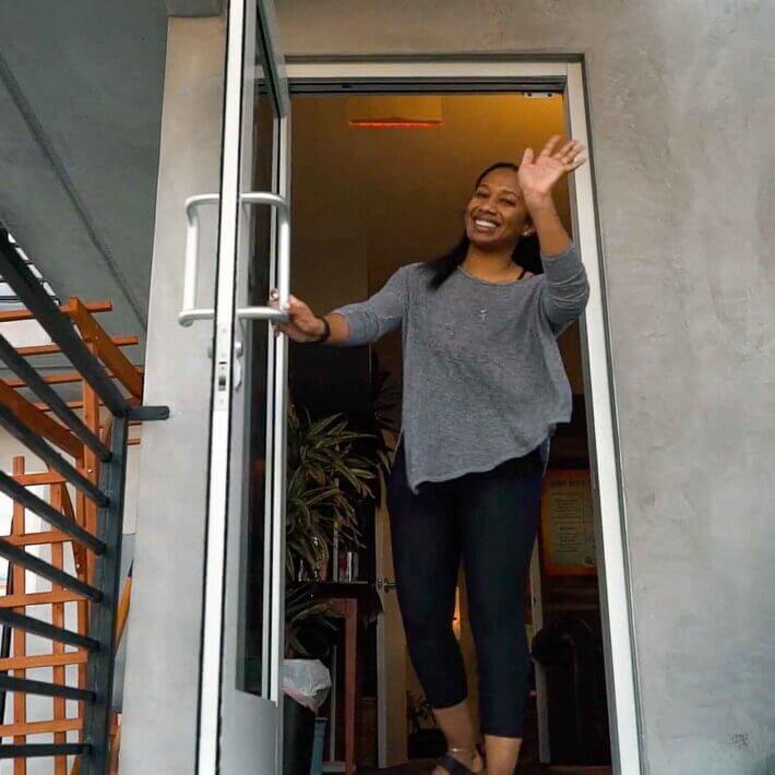 Friendly tutor waves from the entrance of Study Hut Tutoring, highlighting the welcoming and approachable atmosphere that greets every student.